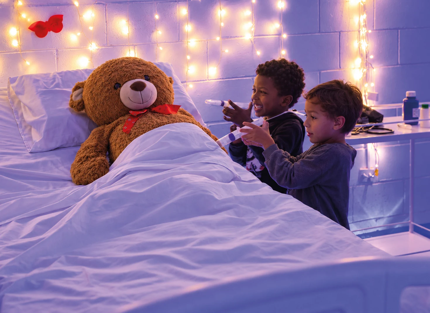 Criança cuidando de um urso de pelúcia no Hospital de Brinquedos